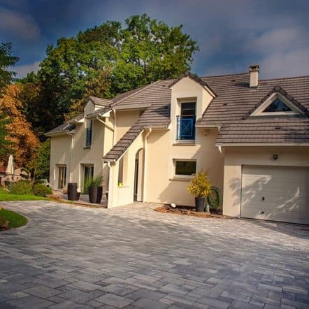 une allée carrossable pavée dans un jardin réalisée par Pauchard Paysage